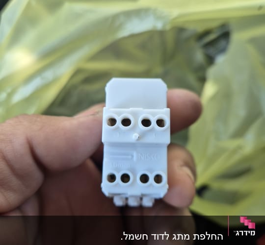 מחבר חשמלי ביד על רקע שקית פלסטיק
